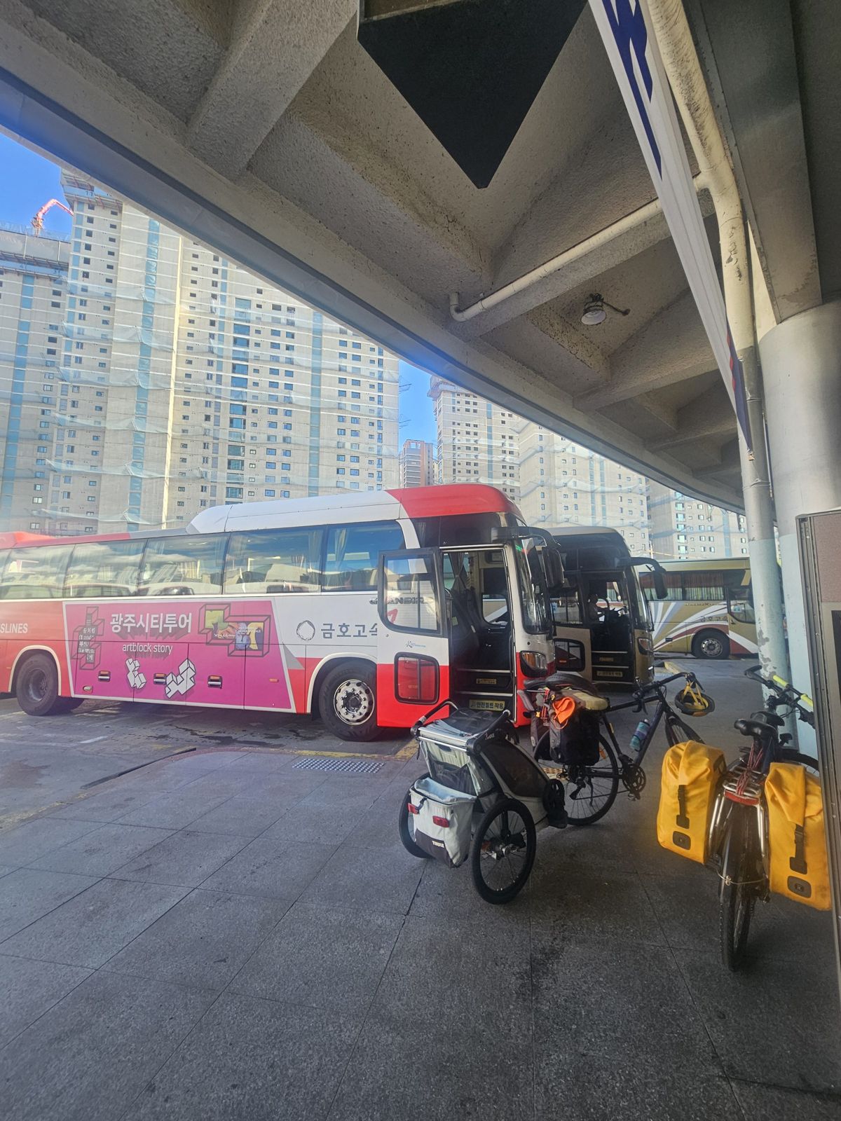 Une vue du terminal de bus à Gwangju, en Corée du Sud, avec des bus garés et des vélos avec remorque.