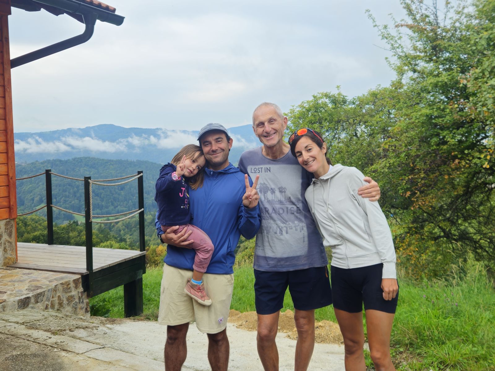 Une famille posant ensemble devant un paysage de montagne, sourire aux lèvres.